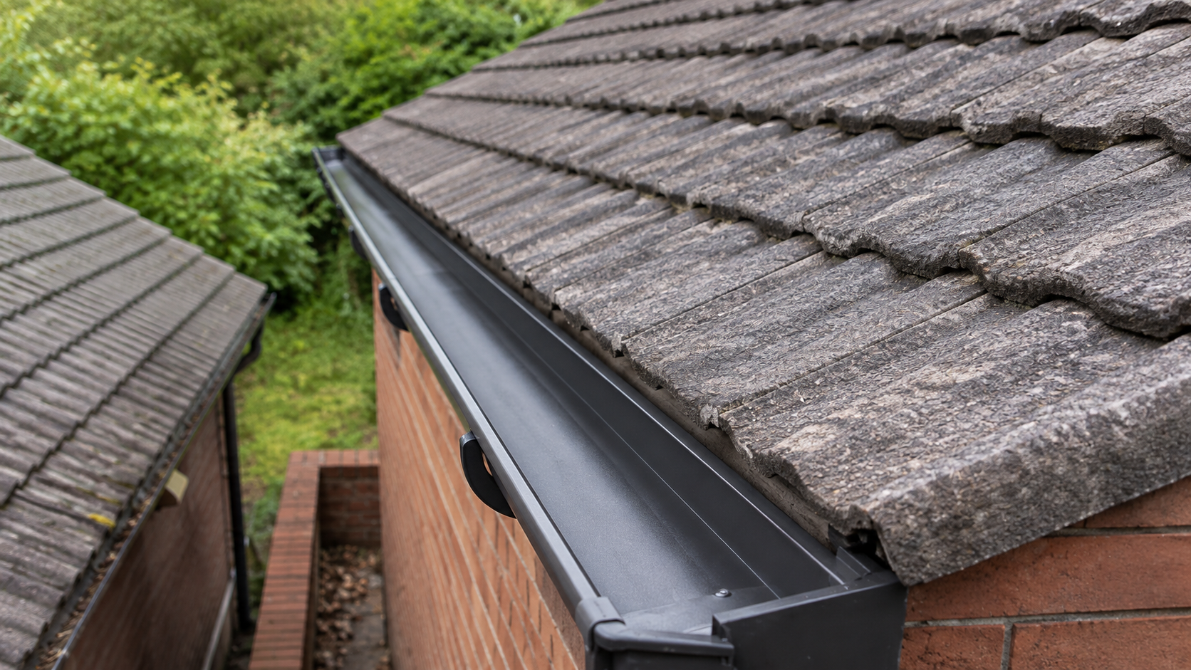 After professional gutter cleaning — the same Birmingham gutter cleared down to the channel floor with bare material visible